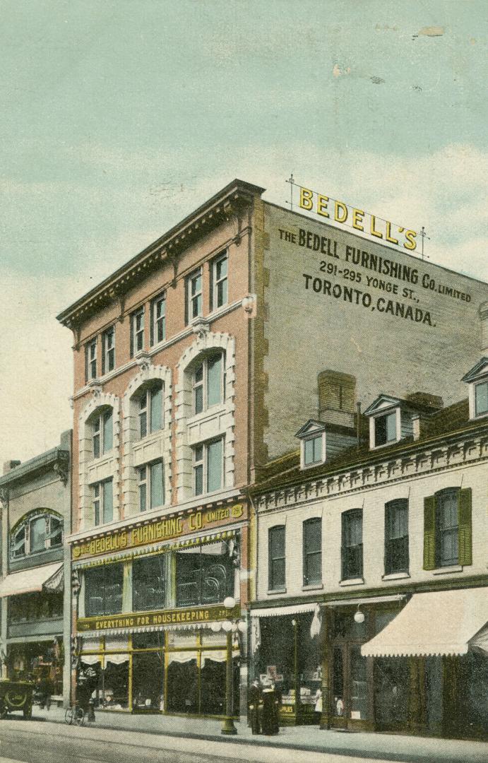 Colour postcard depicting a 4-story building with a rooftop sign "Bedell's" and the side and fr ...