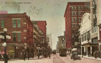 Colour postcard depicting a view of Yonge Street with a streetcar, car, horse-drawn wagons, a m ...