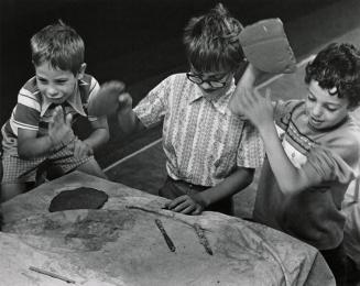 Three boys playing with clay at a table. 