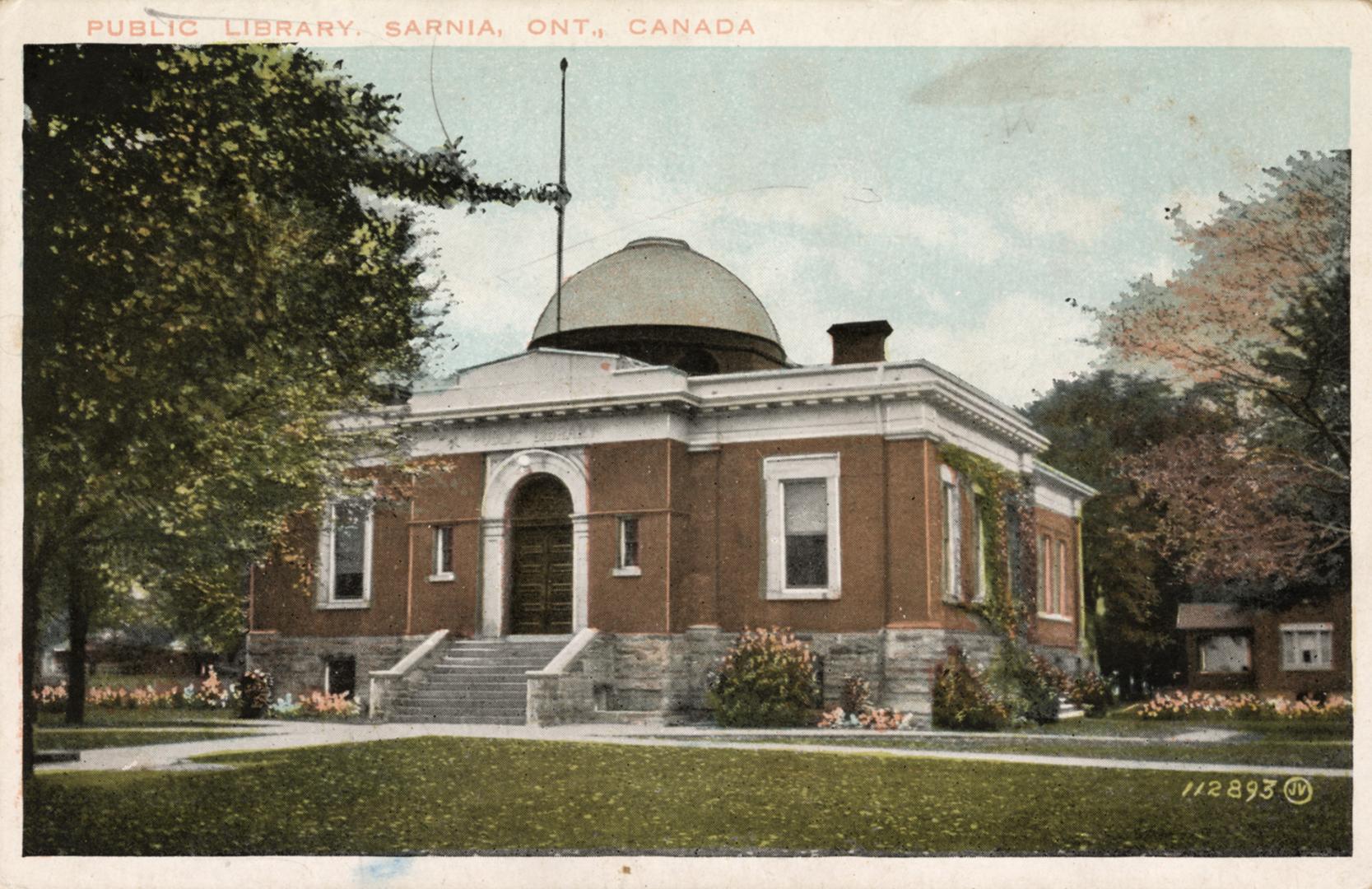 Picture of a brick and stone one storey library building with dome with white border.