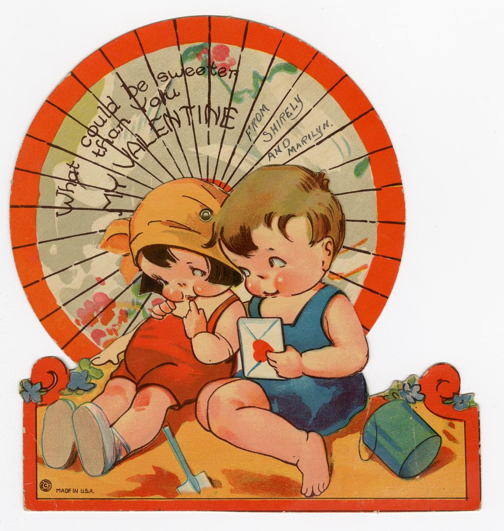 A mechanical card.A boy and girl sit on the beach. The boy's arm is around the girl and he hold ...