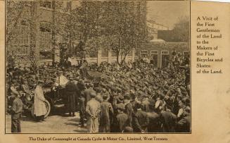 Black and white picture of a huge crowd swarming around a car in front of a warehouse type of b ...