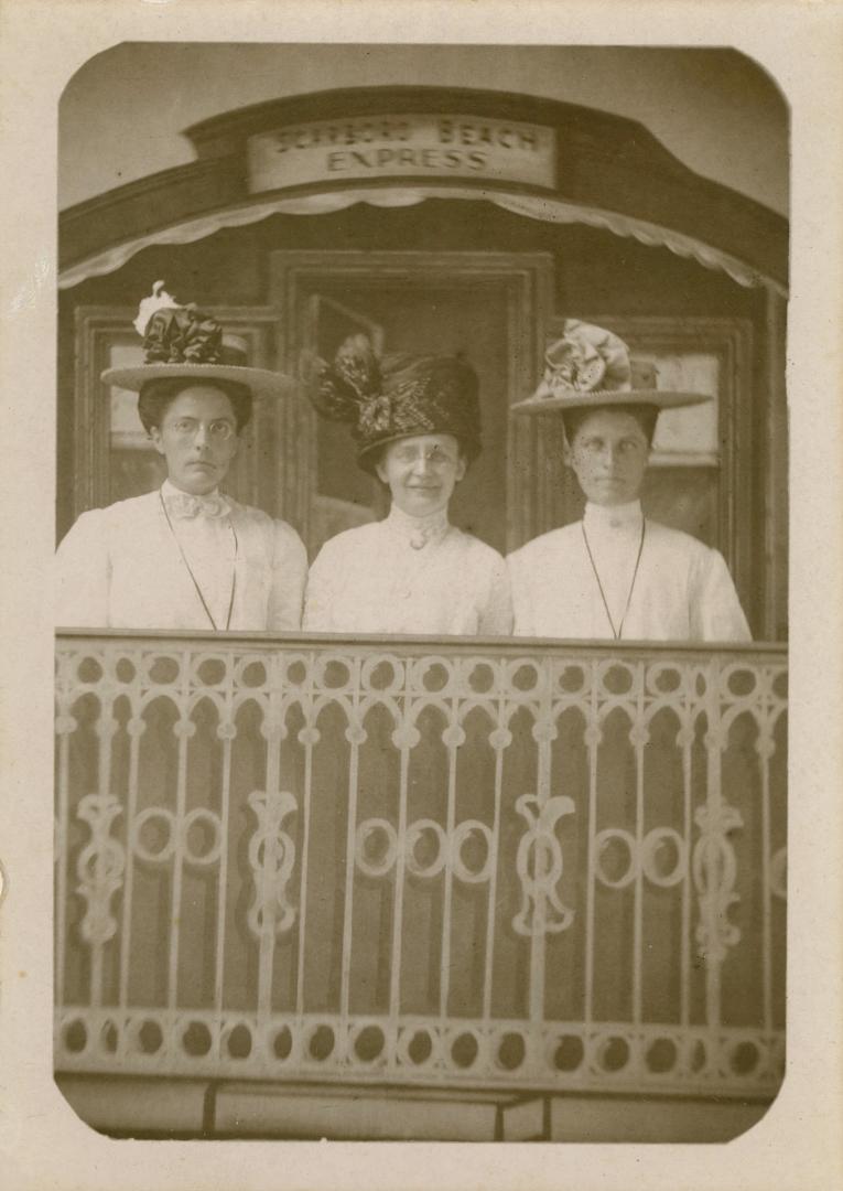 Black and white photograph of three ladies posing for a photograph on a faux caboose.