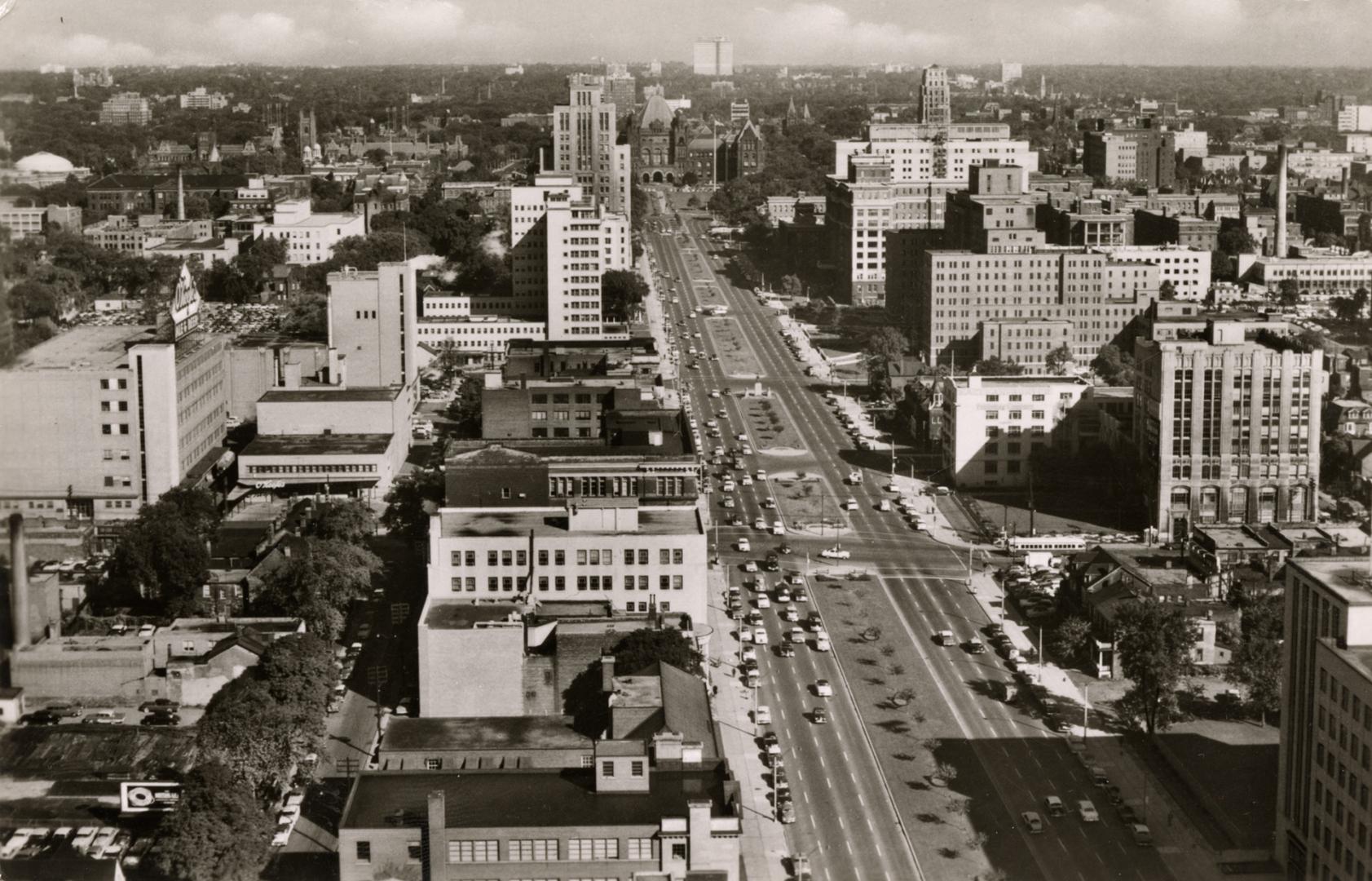 Black and white aerial photograph of a wide, city street.