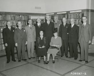 Picture of group of people posing for photograph in a library. 