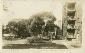 Black and white photograph of large public buildings surrounded by trees and gardens.