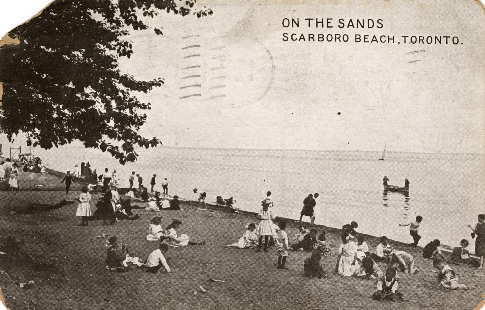 Black and white photograph of many people sitting on a beach watching people in boats and canoe…