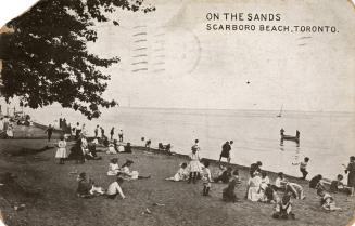 Black and white photograph of many people sitting on a beach watching people in boats and canoe…