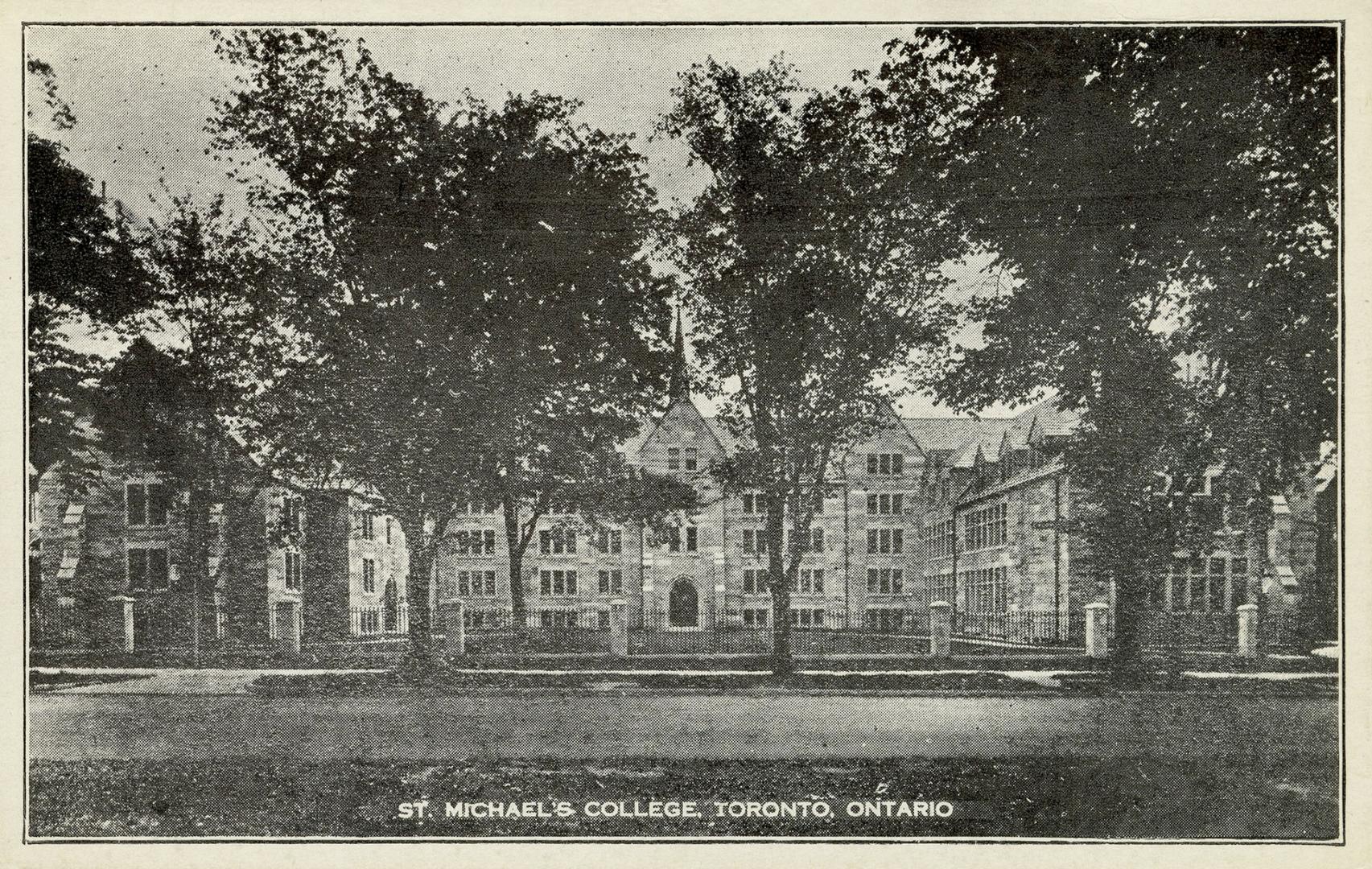 Black and white photograph of a huge collegiate gothic complex surrounded by trees.