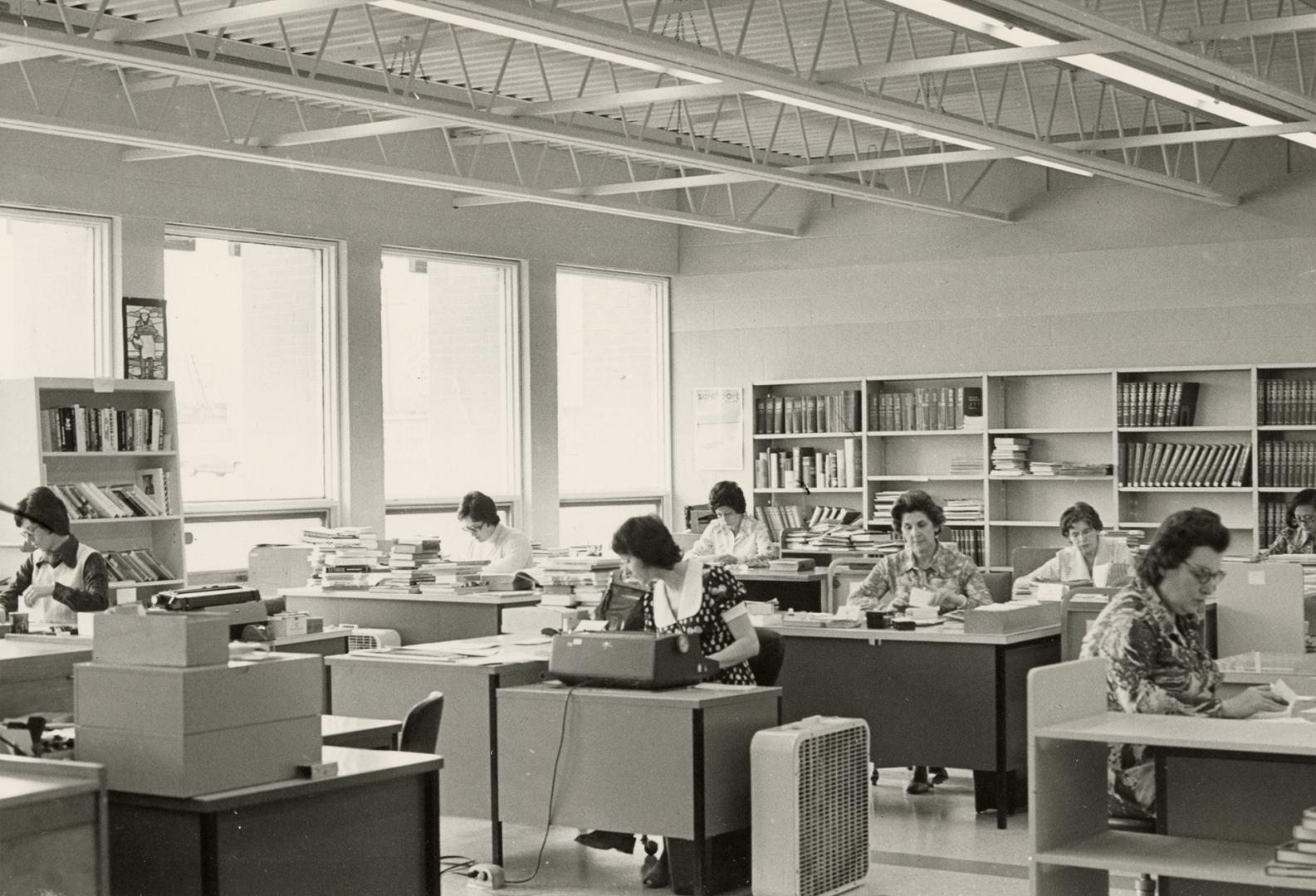 Picture of library staff working in an office seated at desks. 