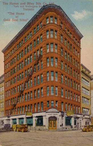 Colorized photograph of an eight story industrial building.