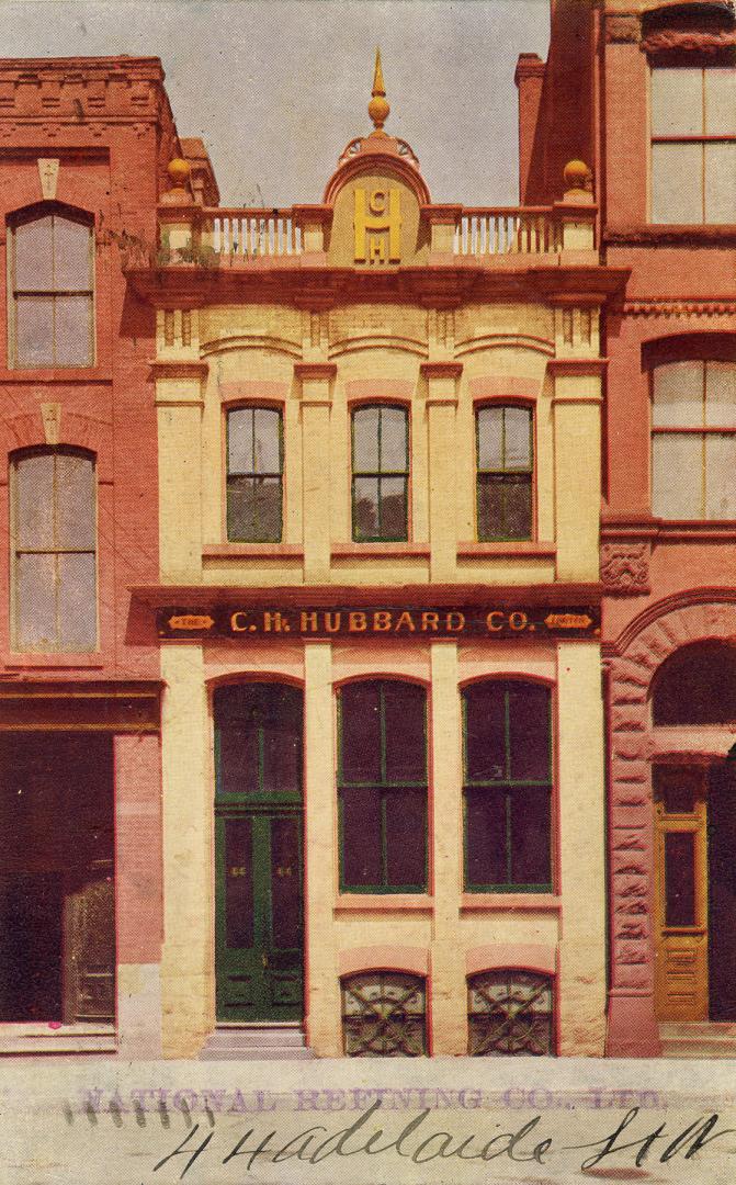 Colorized photograph of a two story retail building.