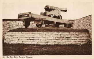 Sepia toned photograph of a cannon sitting on a brick wall.