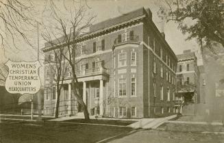 Black and white drawing of a large four story story building with balconies over two front door ...