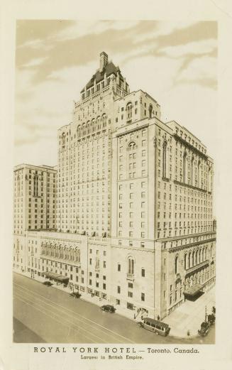 Black and white photograph of very large chateauesque style building taken at night.