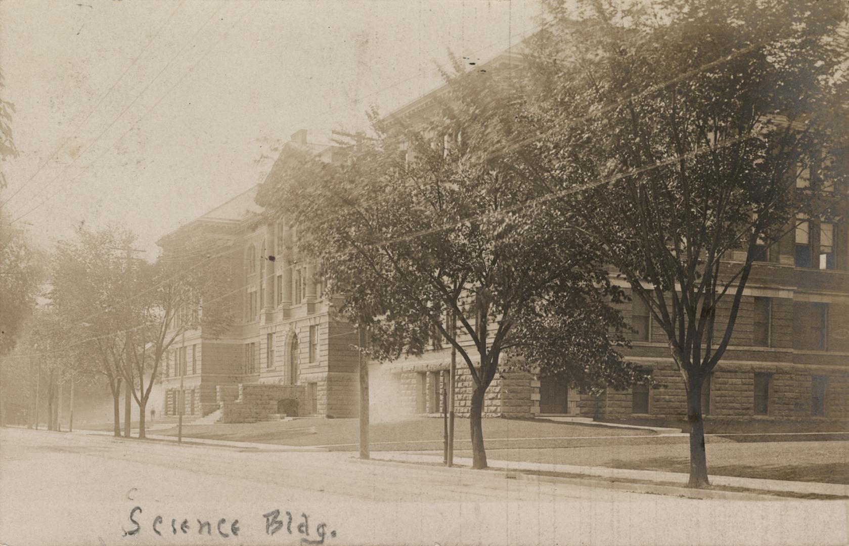 Sepia-toned photo postcard depicting the exterior frontage of a building. A handwritten caption ...