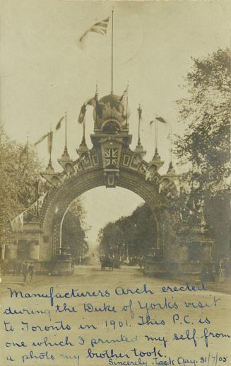 Black and white photograph of a large stone arch spanning a paved road with people and carriage ...