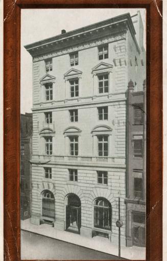 Black and white photo postcard with an auburn-brown frame, depicting the exterior view of a bui…
