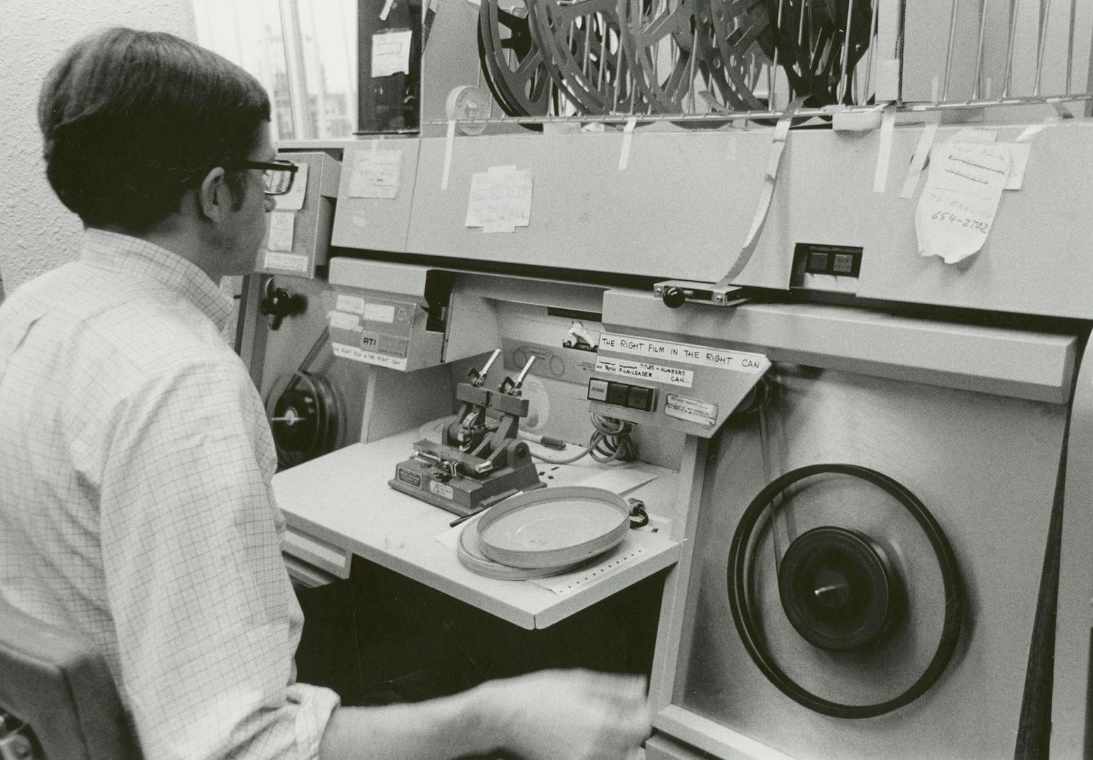 Picture of man using a machine to clean films. 