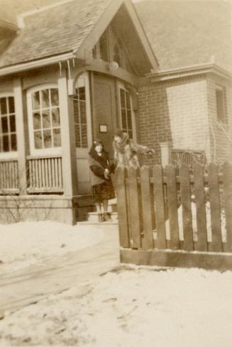 Picture of side of library building and two women outside on a snowy day. 