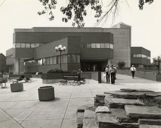 Picture of large concrete library building and sidewalk area.