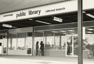 Picture of the outside of a library branch in a strip mall. 