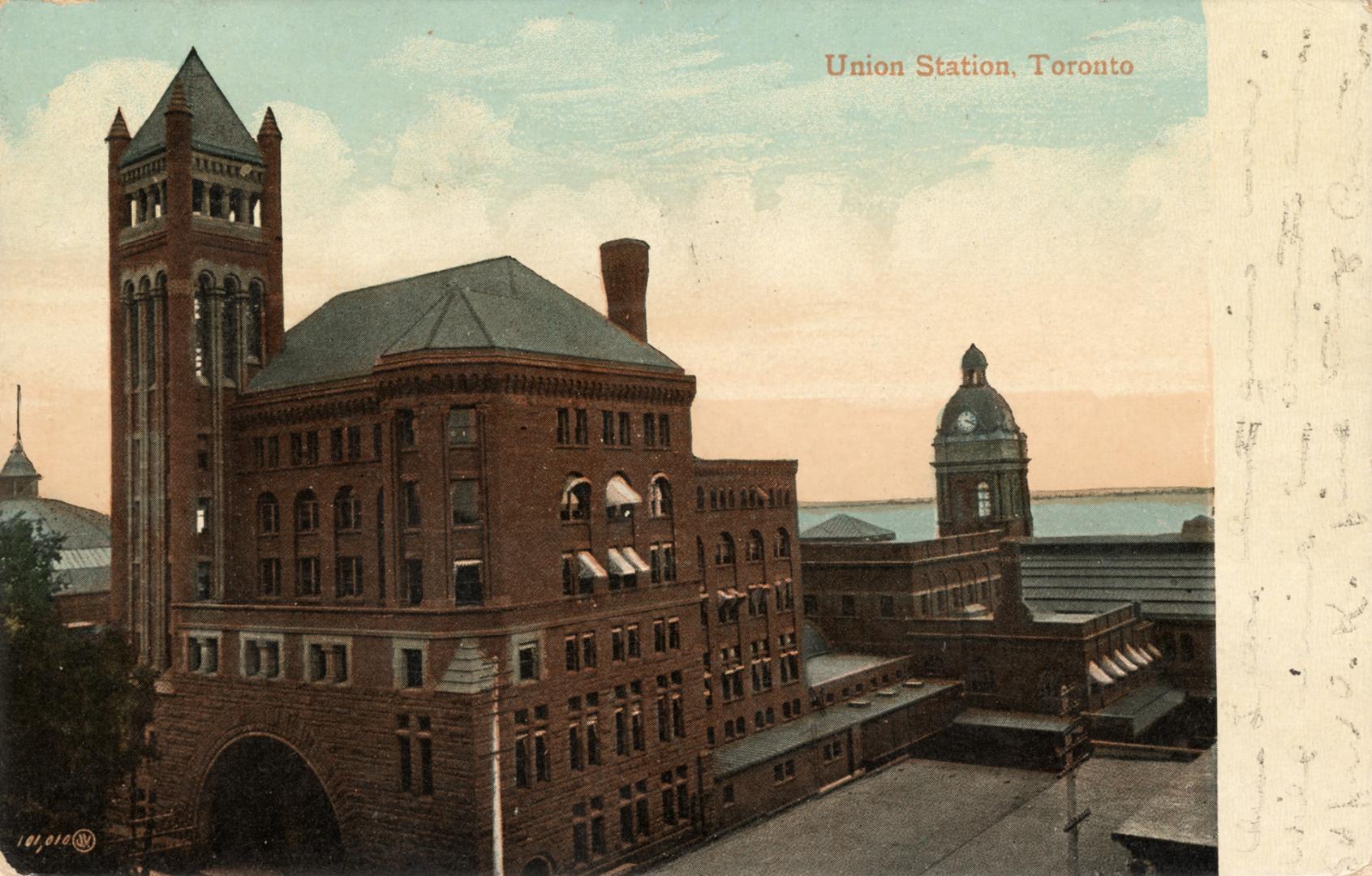 Colour photo postcard depicting an exterior view of Union station, with the entrance arch and t ...