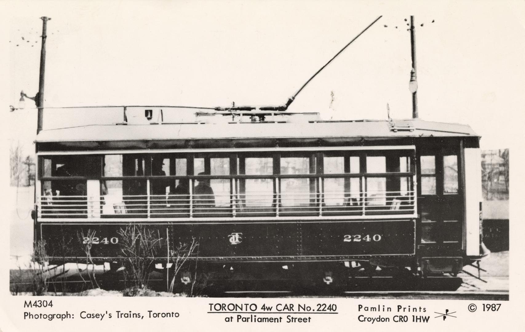 Black and white photo postcard of a streetcar with windowed sides, with the number 2240 visible ...