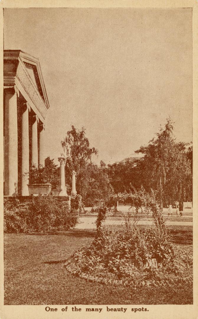 Sepia toned photograph of a formal flower bead outside of a classical styled building.