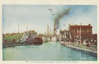 Colorized photograph of crowds of people on a dock watching a line of ships.