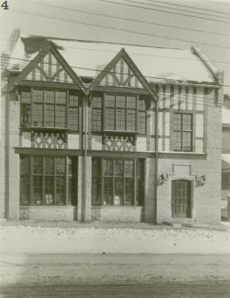 Picture of two storey library and snow on street. 