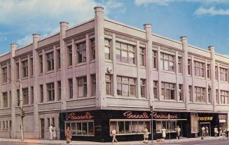 Colour photo postcard depicting the exterior frontage of a three-story building with a restaura ...