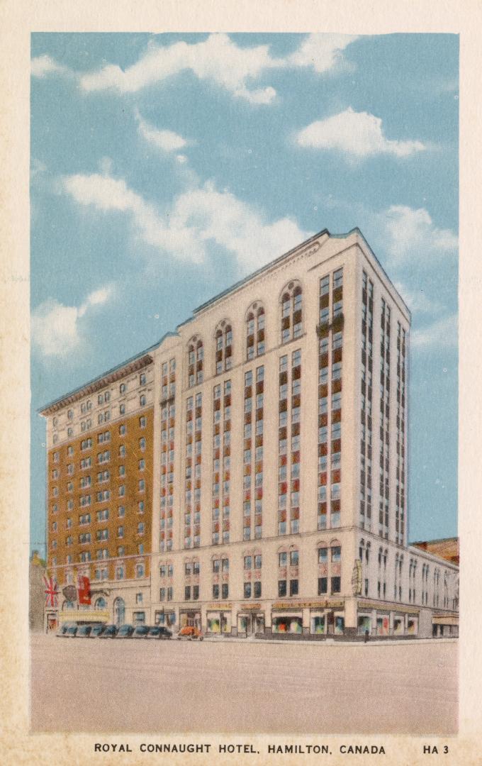 Colorized photograph of a ten story skyscraper with automobiles parked outside of it.