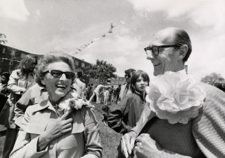 Mr. and Mrs. Robert Stanfield attend a sun drenched neighbourhood fair wearing large paper flow ...