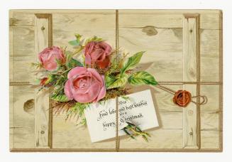 Pink roses and foliage sit atop a wooden panel or crate. A note with holiday wishes is attached ...