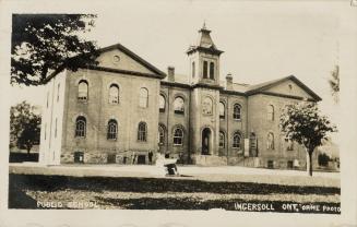 Black and white photograph of a three story collegiate building of Victorian architecture.