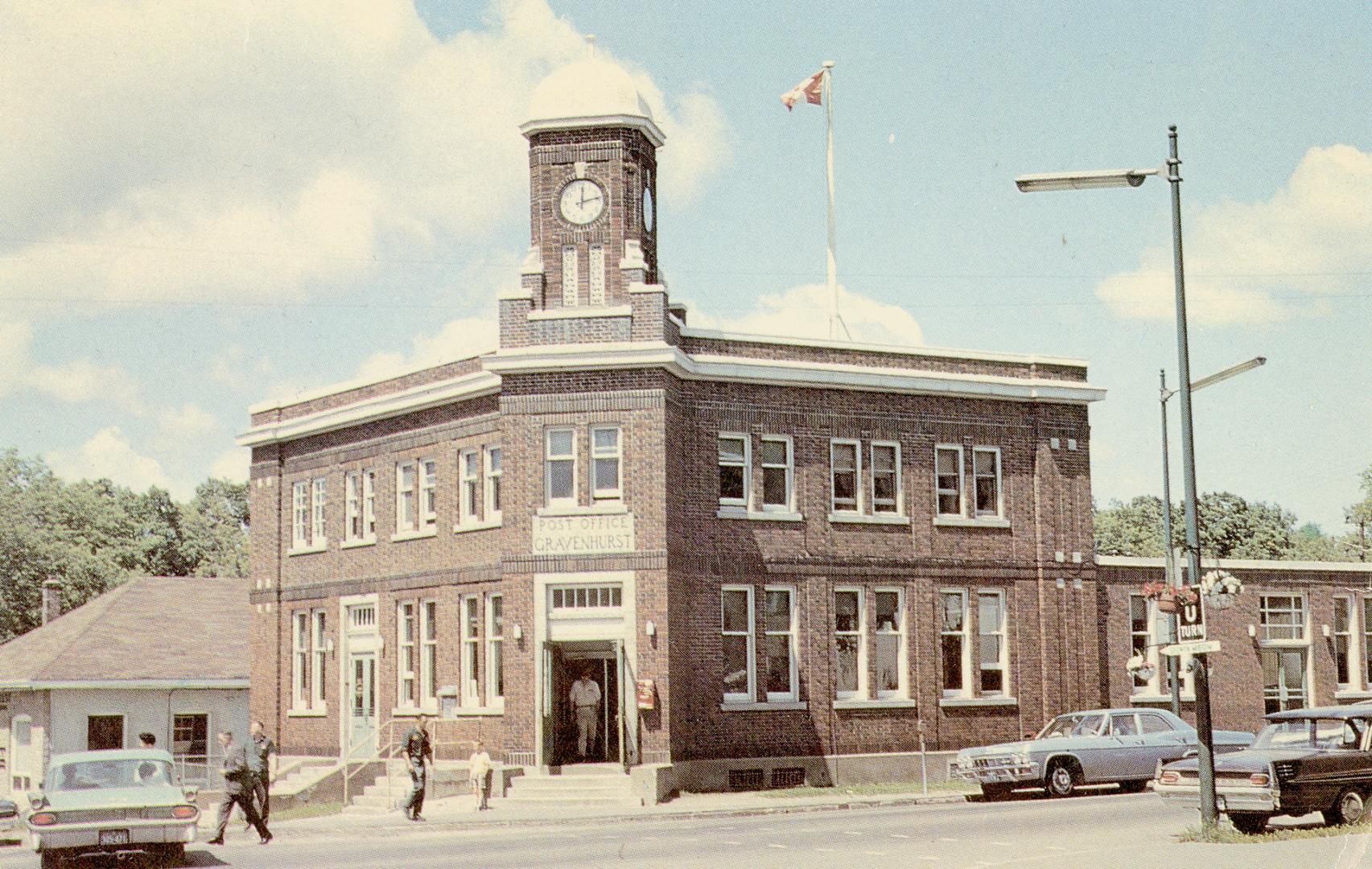 Color photograph of a two-story public building with a clock cupola.