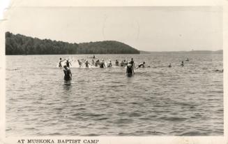 Black and white photograph of a group of swimmers in a lake.