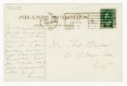 Black and white postcard depicting the exterior frontage of a five-story building with a curved…