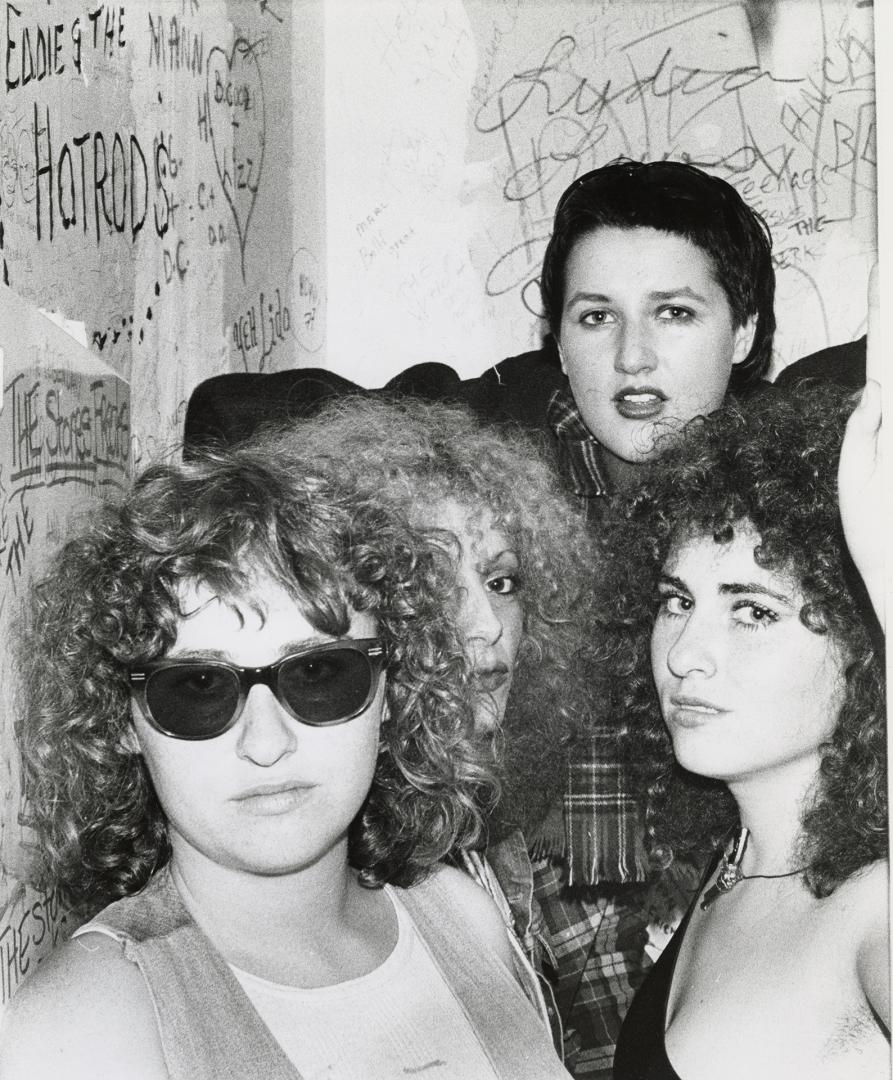 Four young woman against graffiti strewn walls. 