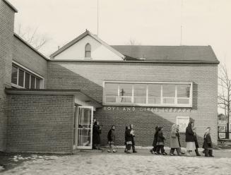 Picture of children coming out of library entrance. 