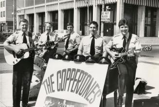 5 men dressed summer police uniforms behind a sign that says, The Coppertones. Their police cap…