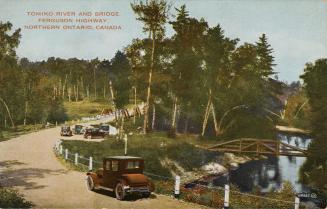 Colorized photograph of automobiles traveling on a dirt road beside a river.
