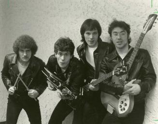 Four young men i black leather jackets, white t-shirts and black jeans against a mottled white …