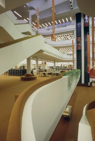 Interior view of multi-storey atrium of a library with orange carpeting, hanging banners and gl…
