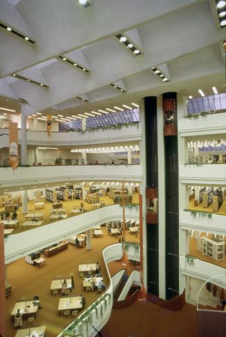 Interior view of atrium of large multi-storey library showing elevators. 