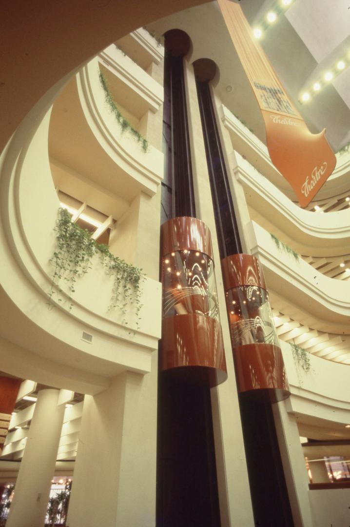 Picture of interior of a library showing glass enclosed elevators in an atrium. 
