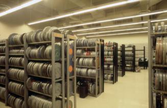 Picture of a row of shelves full of film reels. 