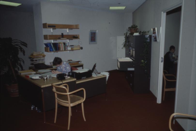 Picture of a person sitting at a desk in an office area 