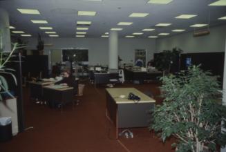 Picture of an office area with several desks. 